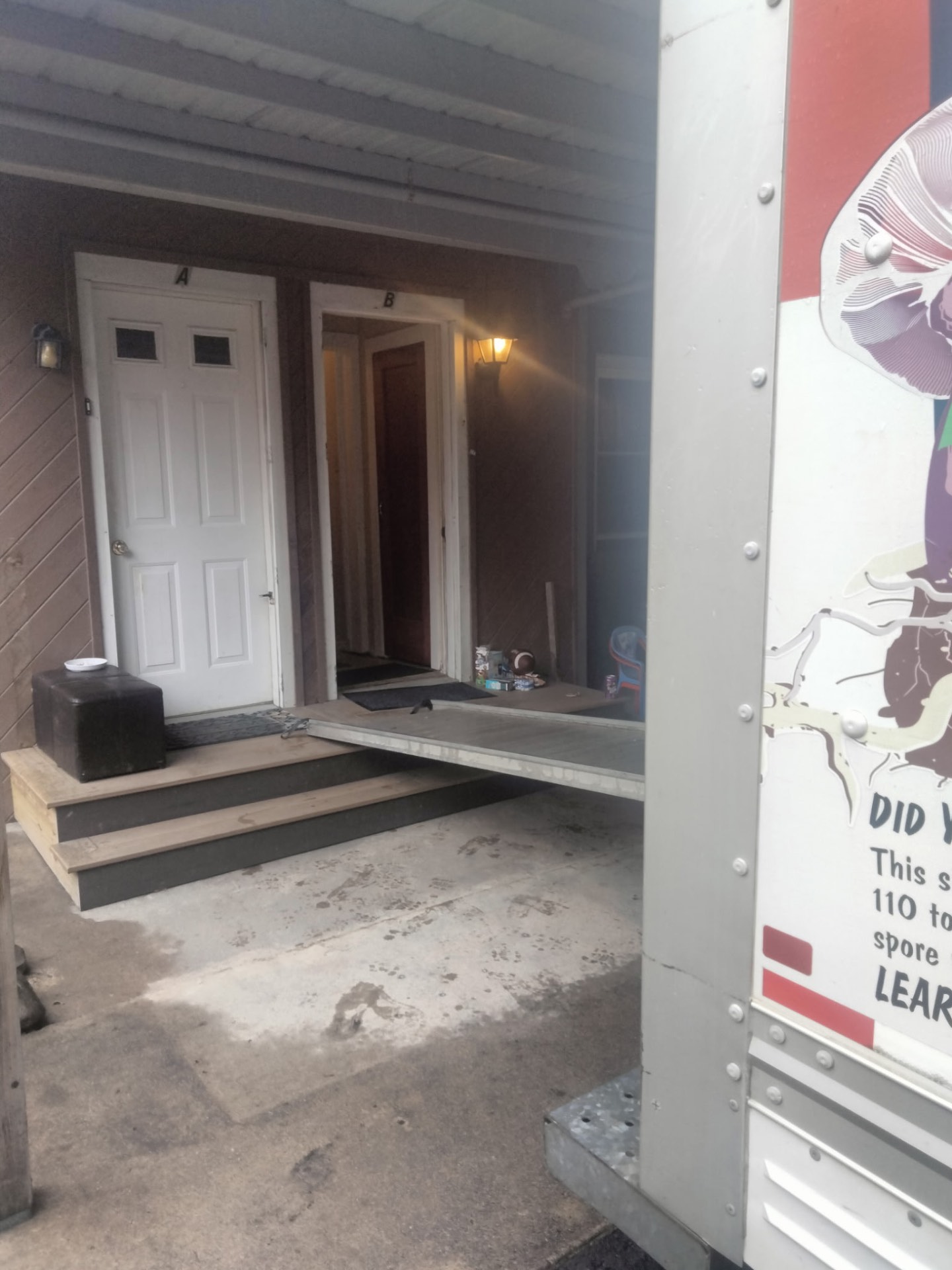 Moving truck ramp laid from the truck to a townhouse porch before loading